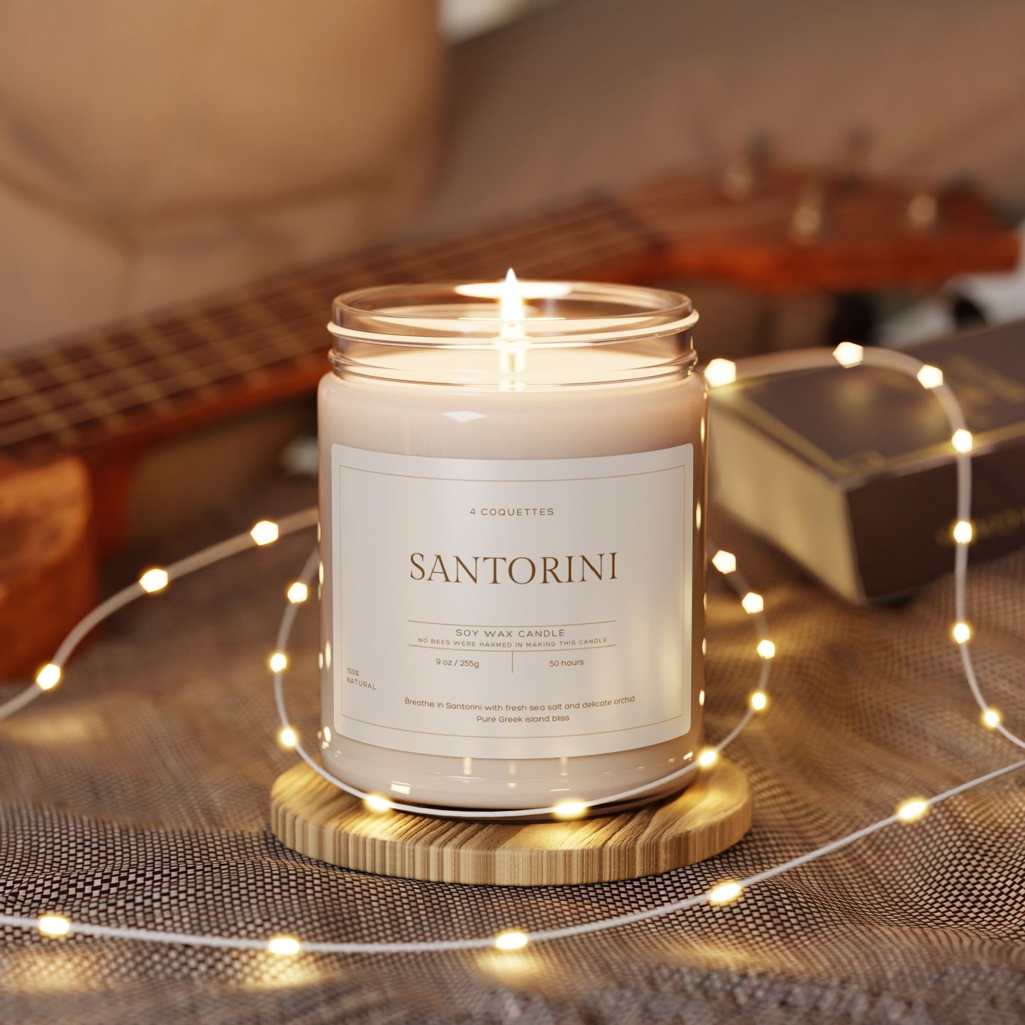 A lit Santorini scented candle on a wooden base, surrounded by soft, glowing string lights, evokes Greek island bliss. A ukulele and a notebook are blurred in the background, creating a cozy and warm atmosphere with this exquisite eco-friendly candle. Perfect for Martin Luther King Jr. Day 2025